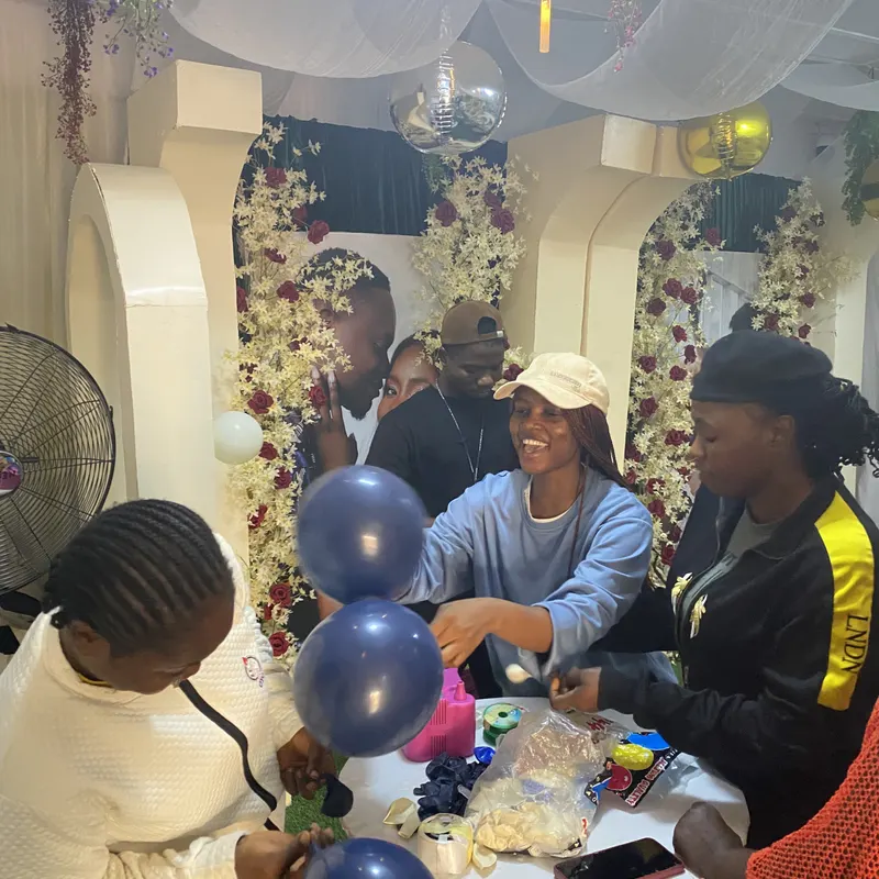 Trainees assembling navy and white balloons at a work table