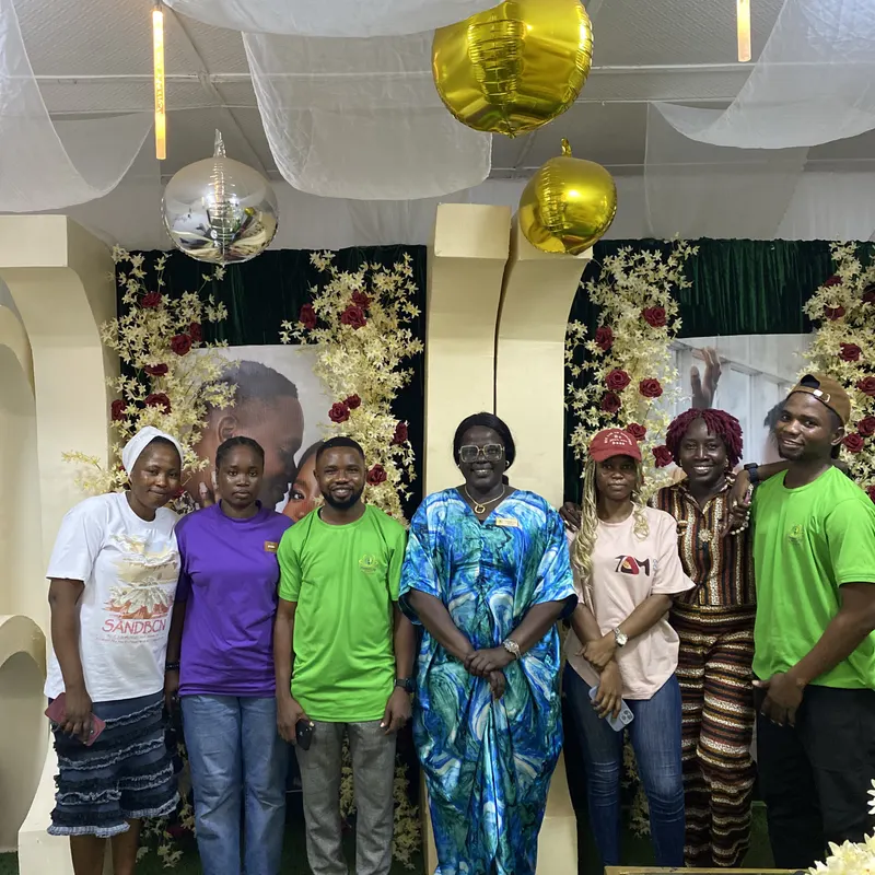 Academy trainees gathered in front of a styled floral backdrop