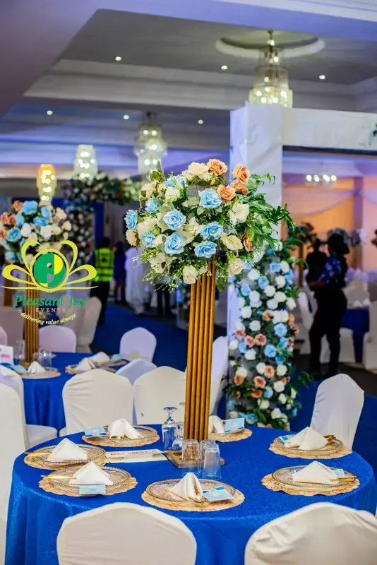 Royal-blue and gold tablescape with towering florals at an 80th birthday