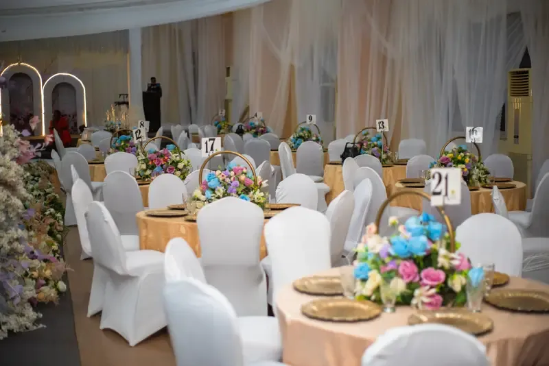Banquet tables with pastel florals and gold place settings at a themed corporate dinner