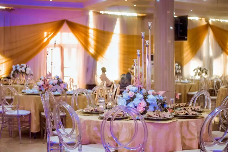 Gold-draped hall with pastel florals styled for a celebration of life
