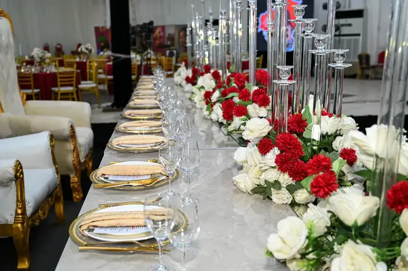 Crystal candelabra banquet table dressed in red and white florals at the Tourism Summit