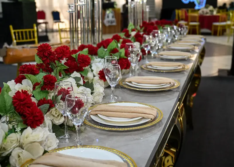 Gold charger place settings along a marble-top banquet table at the Tourism Summit