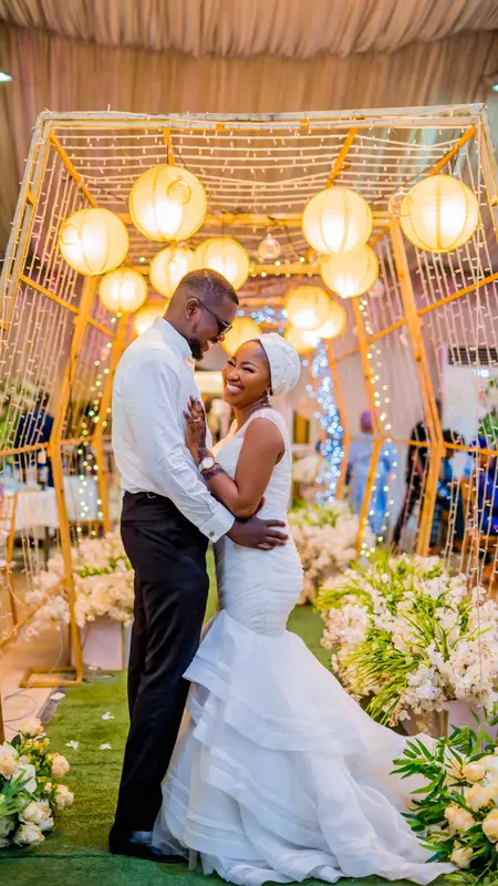 Golden lantern and fairy-light canopy over a styled wedding aisle