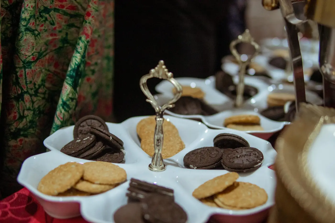 Cookies and treats presented on tiered silver stands at an event refreshment table